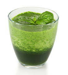 Glass of green vegetable juice with basil isolated on white