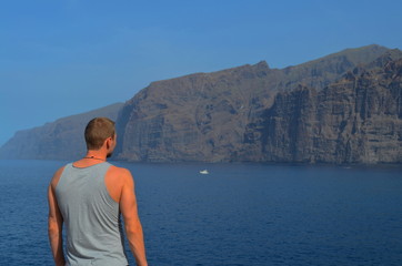 Mann von hinten stehend am Meer mit Blick auf Küste Klippen und Wasser, Teneriffa, Spanien.