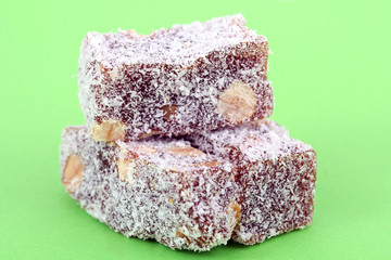 stack, heap of turkish delight with coconut on green background
