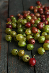 Red and green gooseberry on wooden table close-up