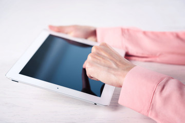 Woman using digital tablet on table close up