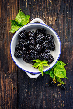 Fresh blackberries in a bowl on wooden table