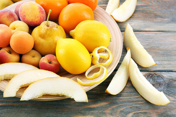 Heap of fresh fruits on wooden table close up
