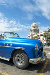 Classic vintage blue American convertible car parked in front of the Capitolio building in Central Havana, Cuba