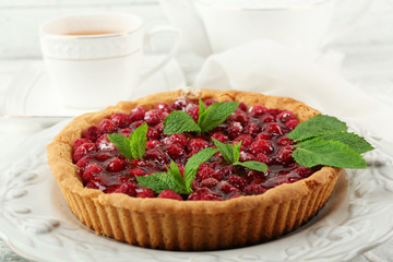 Tart with raspberries and tasty tea, on color  wooden background