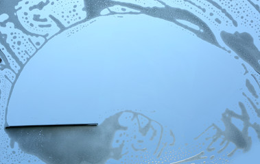 Washing window with soap and foam, closeup