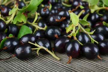 Pile of black currants on wooden table, closeup