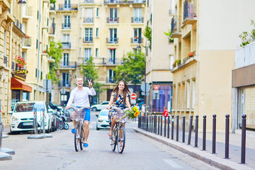 Young couple using bicycles in Paris, France