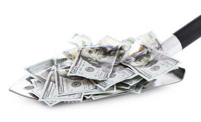 Shovel lifts dollar bills on white background