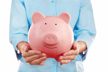 Female hands holding pink piggy bank, closeup