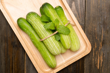 Raw cucumber on wooden plate