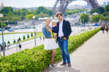 Happy family of three in Paris near the Eiffel tower