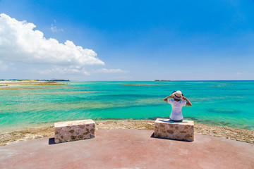沖縄の海と空を見つめる女性