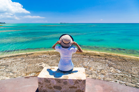 沖縄の海と空を見つめる女性