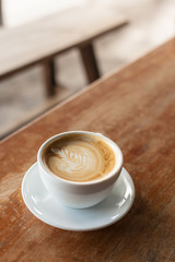 Hot cappuccino on the wooden table