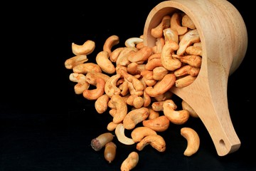 heap cashew nuts and salt on black background