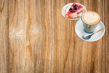 Latte art and cake on wood background