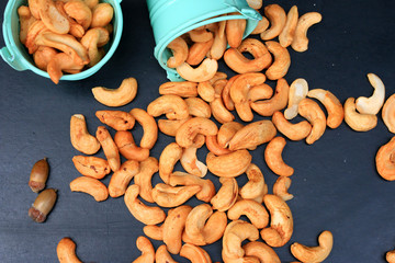 heap cashew nuts and salt on black background