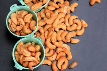 heap cashew nuts and salt on black background