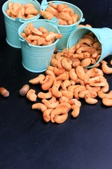 heap cashew nuts and salt on black background
