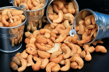 heap cashew nuts and salt on black background