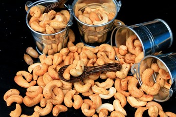 heap cashew nuts and salt on black background