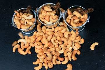 heap cashew nuts and salt on black background