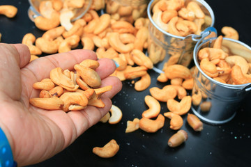 heap cashew nuts and salt on black background
