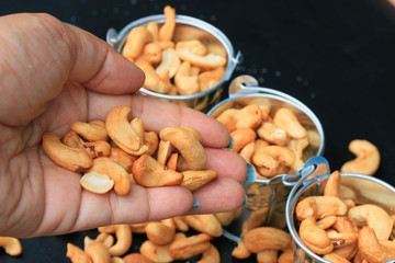 heap cashew nuts and salt on black background