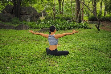 Young woman doing yoga exercises in the garden park