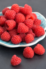 Ripe sweet raspberries on a plate on table