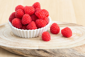 Ripe sweet raspberries on a plate on table