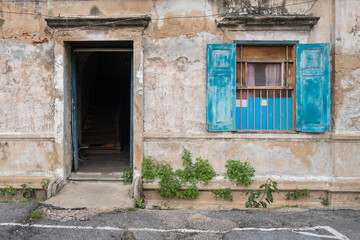 Old wooden blue door and window in the wall of old building.
