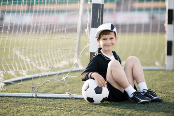 boy plays football on stadium