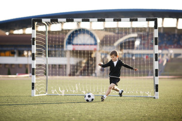 boy plays football on stadium