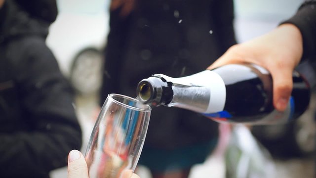 pouring of champagne to the glasses in wedding day at outdoor
