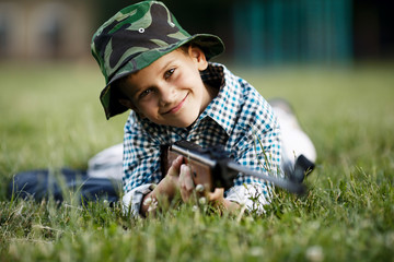 little boy with airgun outdoors