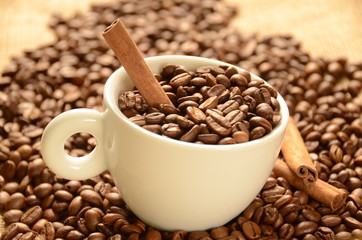 Coffee beans with cinnamon and a cup