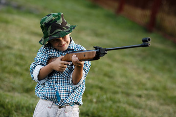 Fototapeta premium little boy with airgun outdoors