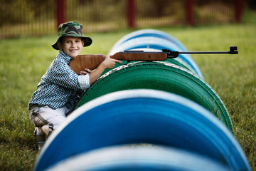 little boy with airgun outdoors
