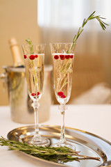 Two glasses of Champagne and rosemary branch on a table