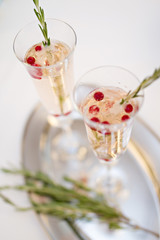 Two glasses of Champagne and rosemary branch on a table