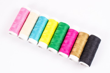 multicolor sewing threads on white background,