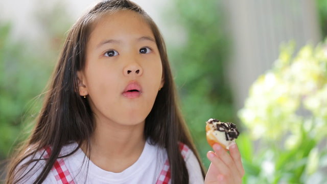 Little asian child eating donut sweet food