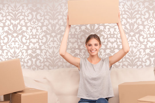 Cheerful young wife holding box 