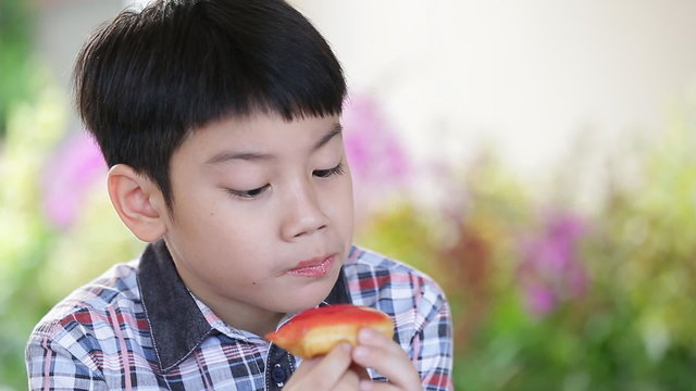Little asian child eating donut sweet food