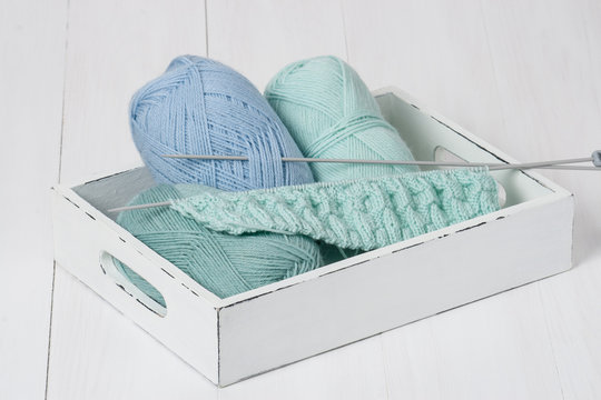 Knitting Accessories In Old Wooden Tray. Yarn Balls. Knit Needle