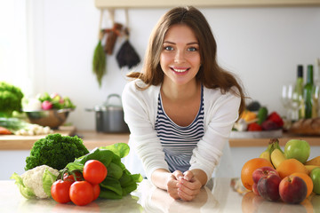 Young woman standing near desk in the kitchen