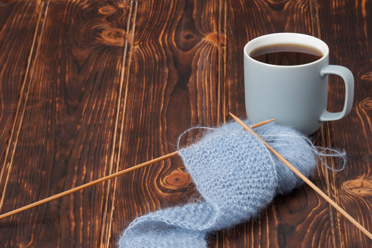 Yarn Balls. Knit Needles. Mug Of Tea. Wooden Table