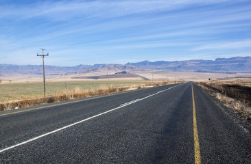 Straight Asphalt Road with Mountains in Background